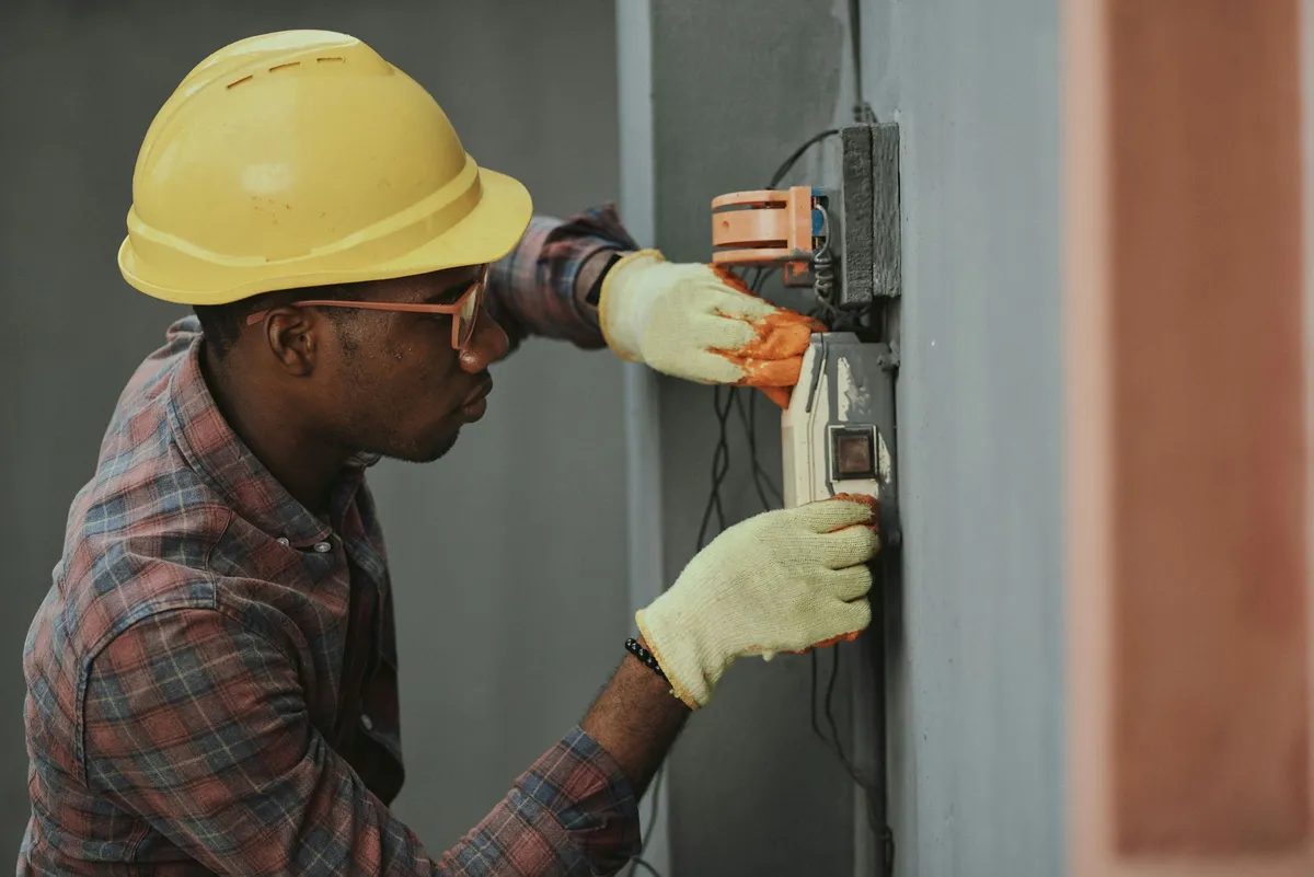 Electrician wiring an exterior electrical service mast on a house — illustrative stock photo, not an actual Pahrump job site